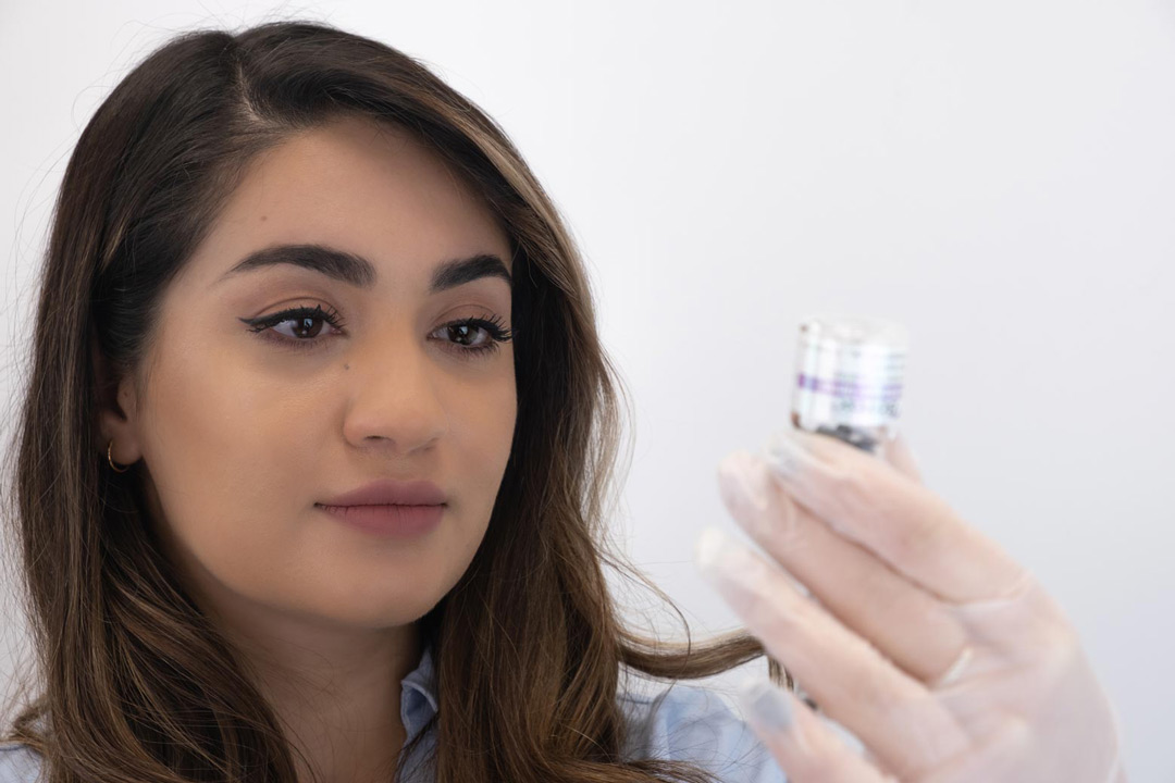 Dr Yalda holds up a bottle of product