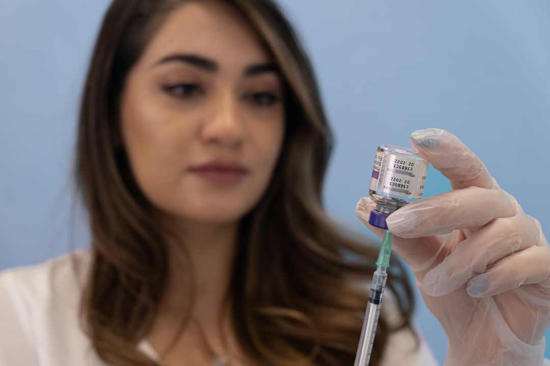 Dr Yalda holds a bottle of product, measuring it with a medical syringe